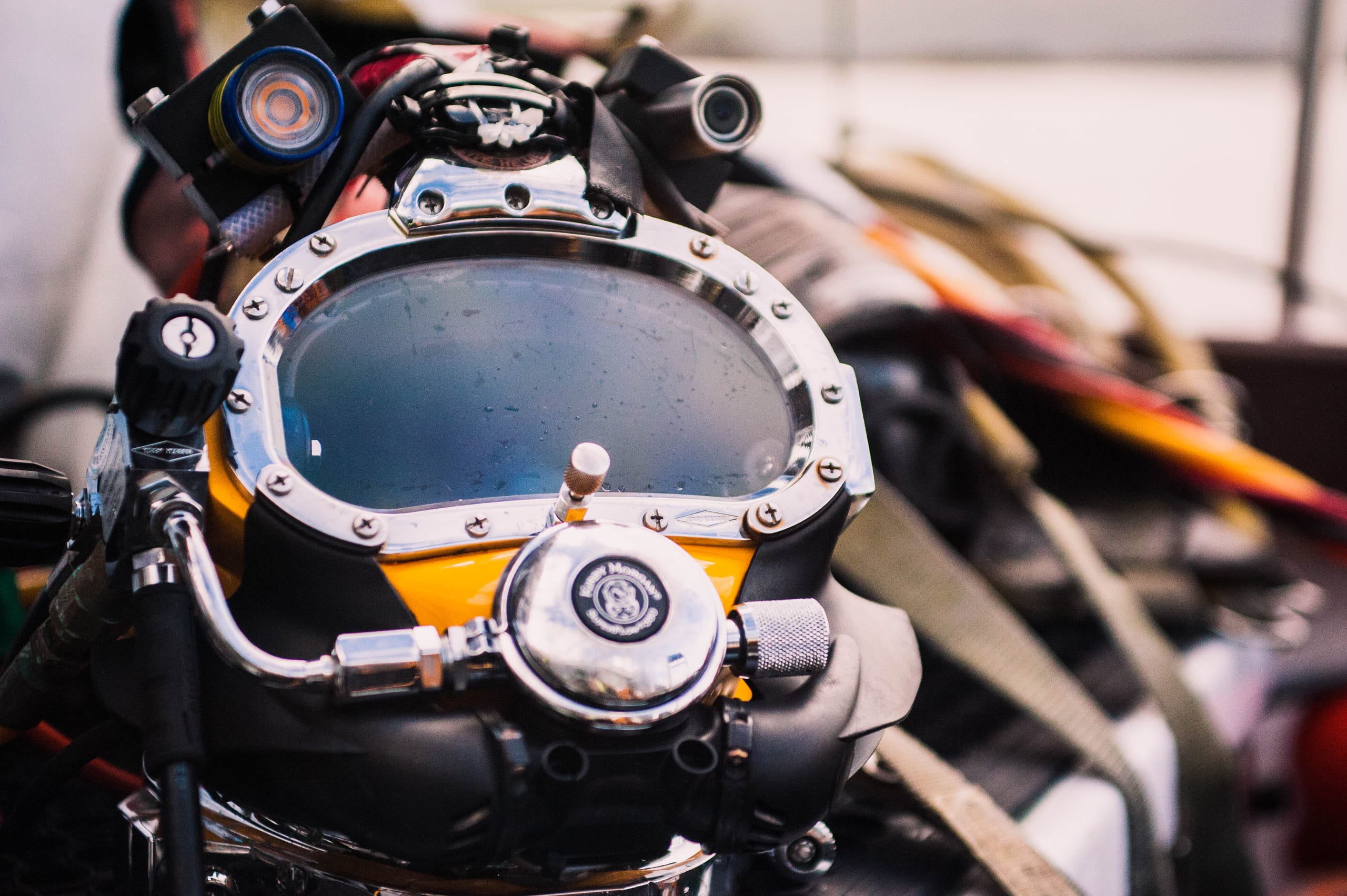 Close detail of a surface-supplied commercial diving helmet and its fittings.